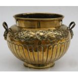 A brass two handled planter with embossed foliate decoration. 20cm (8 ins) high