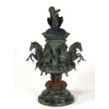 A bronzed centre piece decorated with hippocampus and cherubs, surmounted with a further cherub