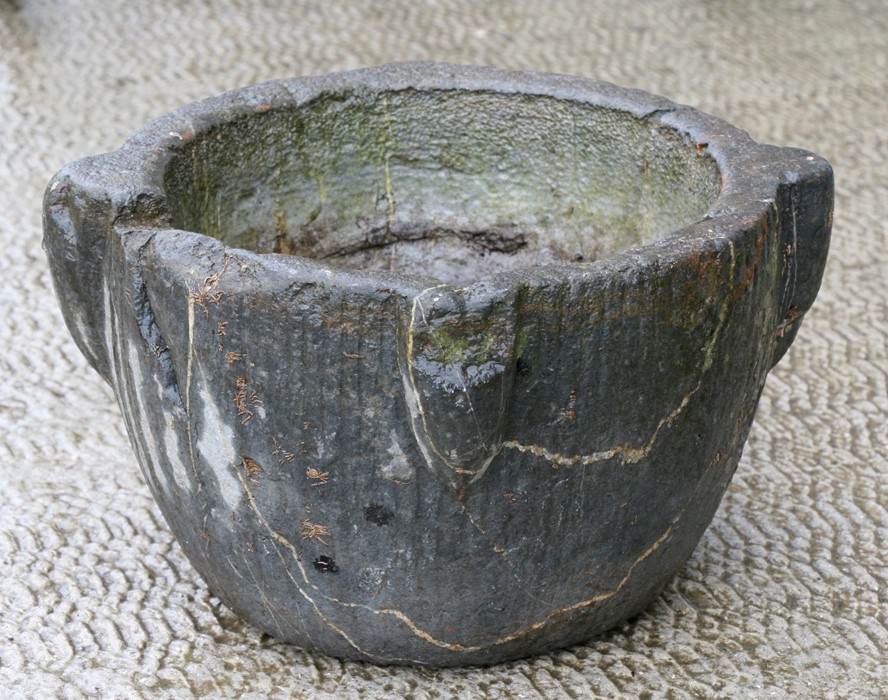 An early large stone mortar, 33cms (13ins) diameter.