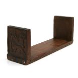 A carved oak book rack, one end carved with riders on horseback the other a lion. 49cm (19.25 ins)
