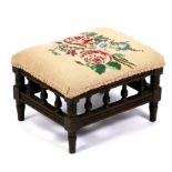 A late 19th century walnut footstool with needlework seat. 33cm (13 ins) wide