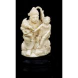 An early 20th century Indian ivory group depicting a seated figure with a child and Ganesh on his