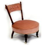 An Edwardian walnut pink upholstered nursing chair.