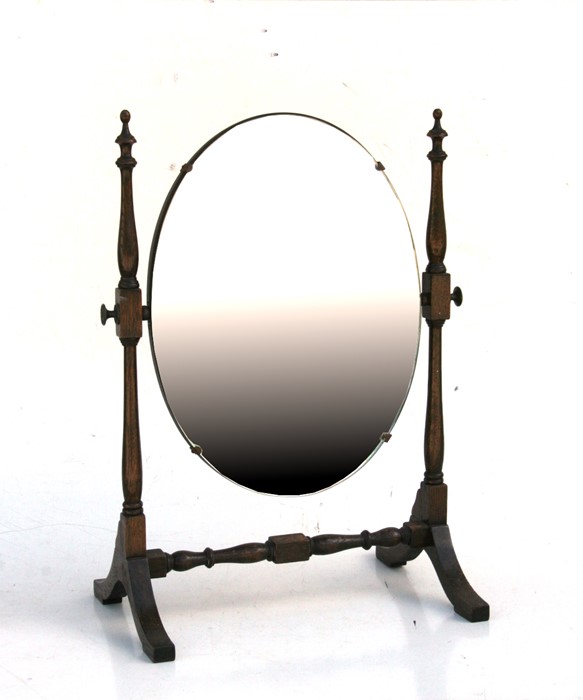 An oak oval dressing table mirror. 37cm (14.5 ins) wide