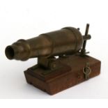 A detailed 20th century brass barrelled signal cannon with elevating screw mounted on a wood