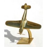 A WW2 brass model of a diving Supermarine Spitfire with spinning propeller mounted on a brass stand.