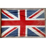 A large early 20th century British Made printed cotton patriotic Union Jack flag attached to a pole,