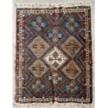 A Persian Shiraz hand knotted woollen rug with geometric design on a blue ground, 184 by 142cms (