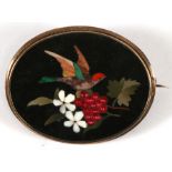 A Victorian pietra dura brooch in a yellow metal mount, decorated with a bird, flowers & fruit, 5cms