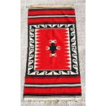 A flat weave runner or wall hanging, possibly Native American Navajo, with geometric design on a red