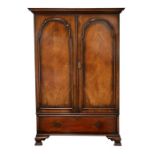 An early 20th century figured walnut wardrobe, the pair of quarter veneered doors above a single