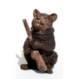 A cold painted bronze match striker in the form of a bear holding a rifle and smoking a cigar, 7.