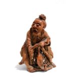 A Chinese carved bamboo figure depicting a fisherman and his catch, 13cms (5ins) high.