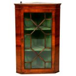 A Georgian style walnut corner cabinet, the astragal glazed door enclosing a shelved interior, 55cms