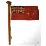 A 20th century printed cotton Red Ensign flag attached to its original jackstaff, probably from a