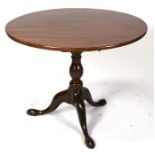 A Georgian mahogany tilt-top table, the circular top on a bird cage support over a turned column and
