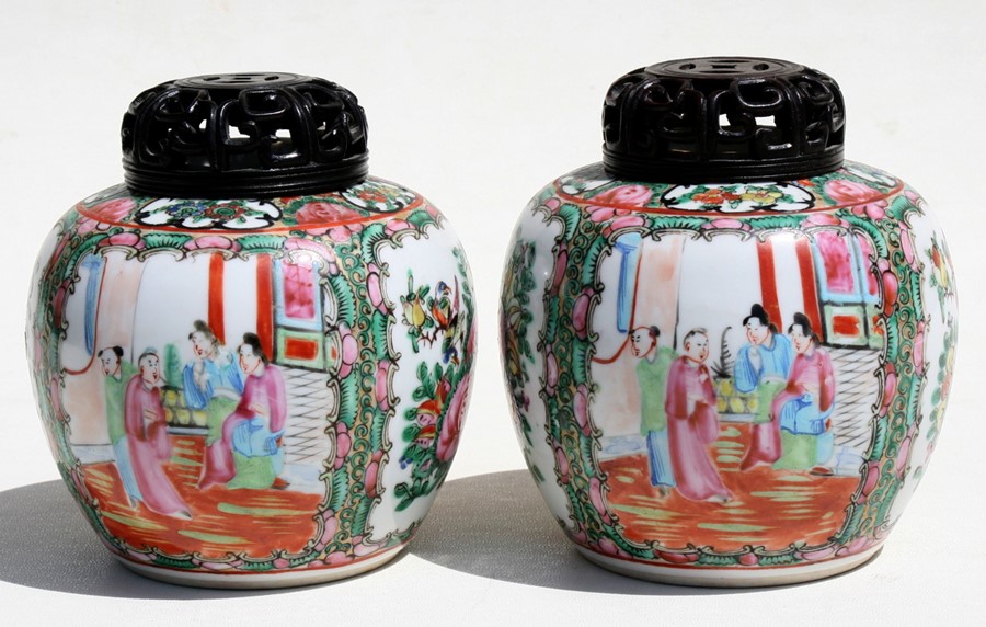 A pair of Chinese famille rose ginger jars decorated with figures, birds and foliage, with pierced