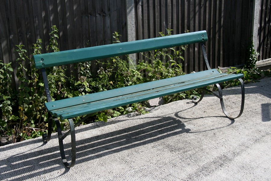 A green painted metal garden bench, 168cms (66ins) wide.