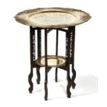 A Chinese brass two-tier tray table decorated with a central scrolling dragon, 56cms (22ins)