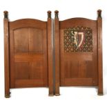 A pair of oak book case ends in the manner of Charles Francis Annesley Voysey, one carved with a