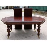 A Victorian style mahogany extending dining table on bulbous turned and fluted legs, with two