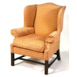 A Georgian style wing back armchair on square reeded legs.