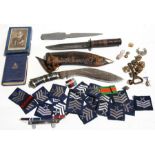 An Indian kukri; together with a quantity of military badges and buttons.
