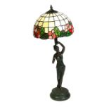 A figural bronzed table lamp with Tiffany style shade, 75cms (29.5ins) high.