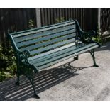 A green painted garden bench with cast iron ends, 127cms (50ins) wide.