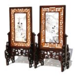A pair of Chinese bone panels on hardwood stands, decorated with figures and calligraphy, 17cms (6.