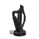 An Irish bog oak harp carved with shamrocks, 17.5cms (7ins) high.