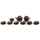 A coconut shell tea set comprising a teapot, sugar bowl, milk jug and cups & saucers.