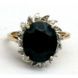 A 9ct gold ring set with a central sapphire surrounded by diamonds, approx UK size 'M'.