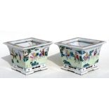 A pair of Chinese famille rose tapering square form planters depicting figures on horseback in a