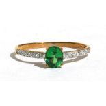 A 9ct gold dress ring set with a single Tsavorite and diamond set shoulders. Approx UK size N