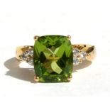 An 18ct gold peridot and diamond ring, the central peridot approx 4.5ct with six diamonds to the