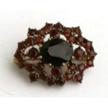 An 8ct gold & garnet brooch.