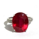 A platinum Mozambique ruby and diamond ring, the central oval ruby approx 13.03ct. Approx UK size N