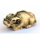 A 19th century Japanese ivory netsuke in the form of a recumbent oxen, 5cm (2ins) long.