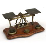 A set of Victorian mahogany and brass desk top postal scales and weights, 24cms (9.5ins) wide.