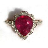 A 9ct gold ruby and diamond ring, the heart shaped ruby surrounded by diamonds with diamond set