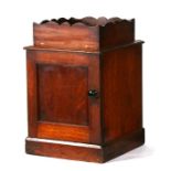 A Victorian mahogany table top cupboard, the shaped galleried top above a single door, on a plinth