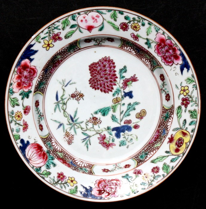 A Chinese famille rose plate decorated with flowers and foliage, 23cms (9ins) diameter.