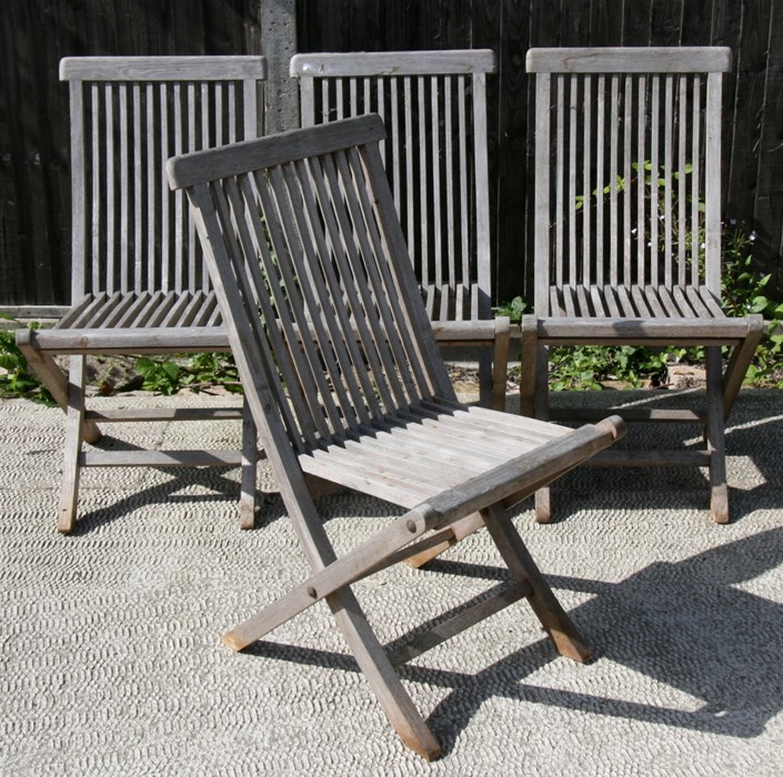 A set of four teak folding garden chairs.