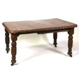 A late 19th century carved oak extending dining table on turned and carved legs, 141cms (55.5ins)