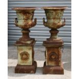 A pair of cast iron twin-handled garden Campana urns on plinth bases, overall height 109cms (