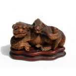 A Chinese carved bamboo dog and puppy mounted on a hardwood plinth, nine character mark to