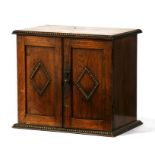 An early 20th century oak two-door smokers cabinet, 29cms (11.5ins) wide.