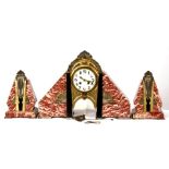 A French Art Deco rouge marble & gilt metal mounted clock garniture, the cream enamel dial with