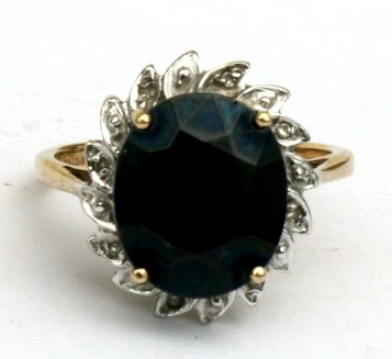 A 9ct gold ring set with a central sapphire surrounded by diamonds, approx UK size 'M'.